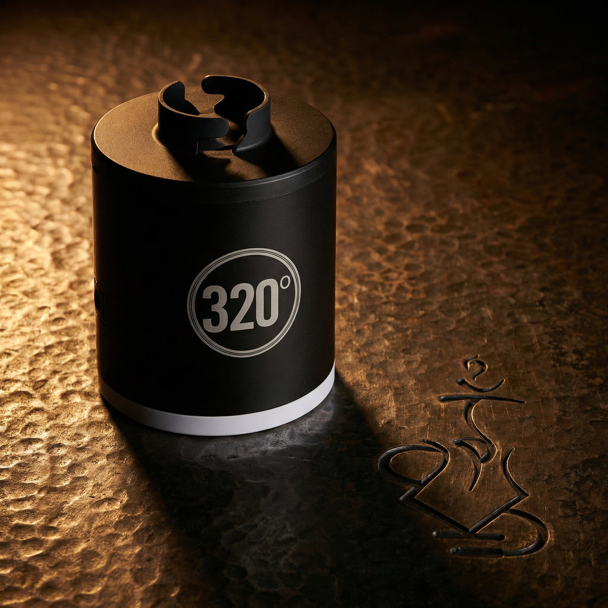 320° LED electric shisha starter pump lit dramatically on a warm hammered bronze surface, showcasing the matte black cylindrical body and circular 320° badge in a dark editorial hero shot., image 2 of 12