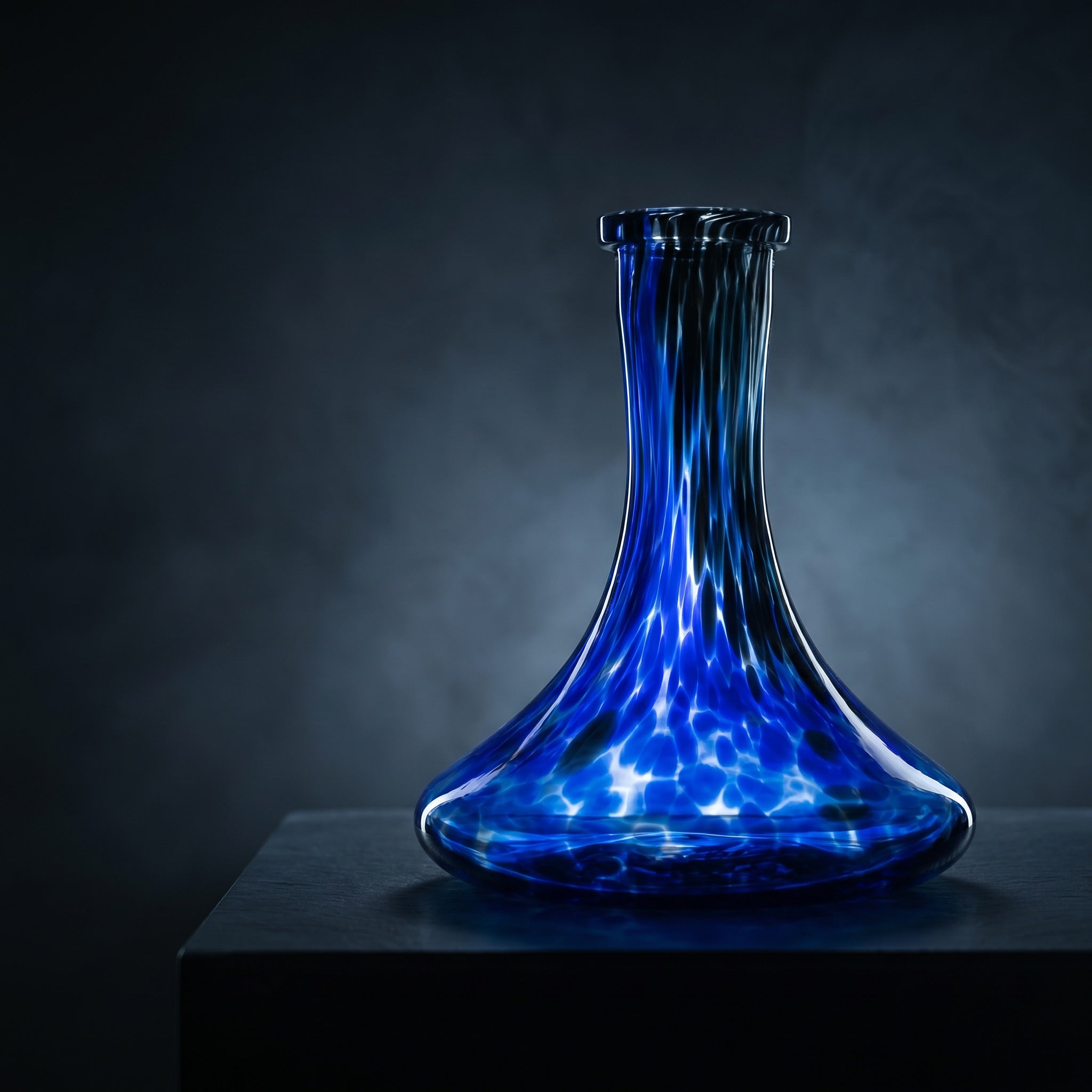 Cobalt Galaxy hand-blown shisha vase glowing on a dark slate plinth in a cool gallery interior