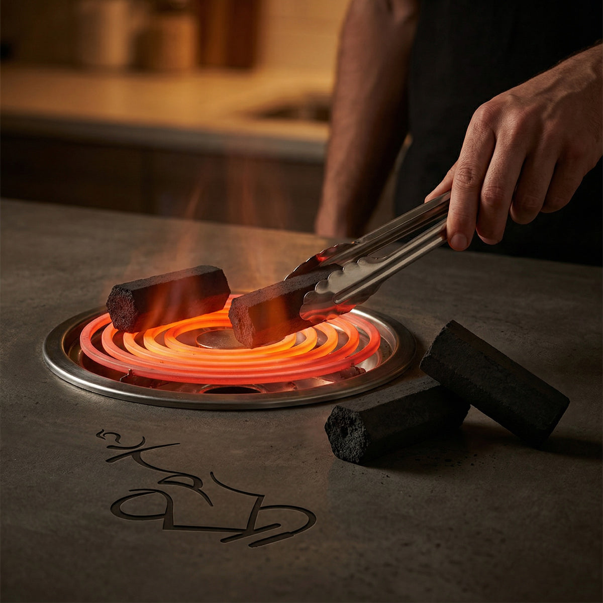 Cerberus Coco Hexa hexagonal coconut charcoal pieces heating on a glowing electric burner coil with hand placing coal using stainless steel tongs during hookah session preparation, image 2 of 5