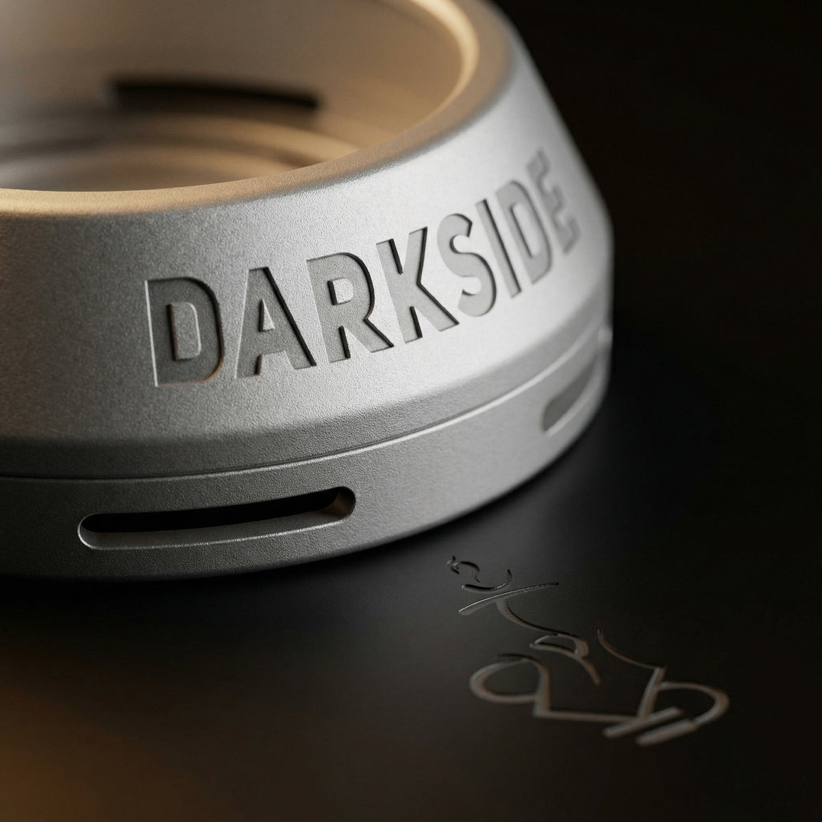 Extreme macro of the Darkside D-Heater's anodised aluminium surface, highlighting the blasted satin texture, vent slot geometry, and debossed wordmark detail., image 18 of 21