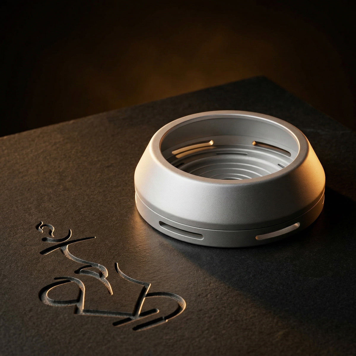 Darkside D-Heater Silver HMD lit dramatically on honed dark basalt, revealing the concentric machined interior coal platform and satin anodised finish., image 15 of 21
