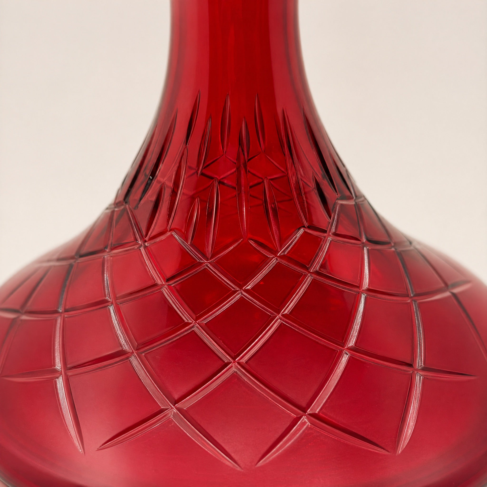 Macro detail of Essentials Ruby Star-Cut shisha vase showing leaf-band collar and radiating star-cut belly motif in ruby glass