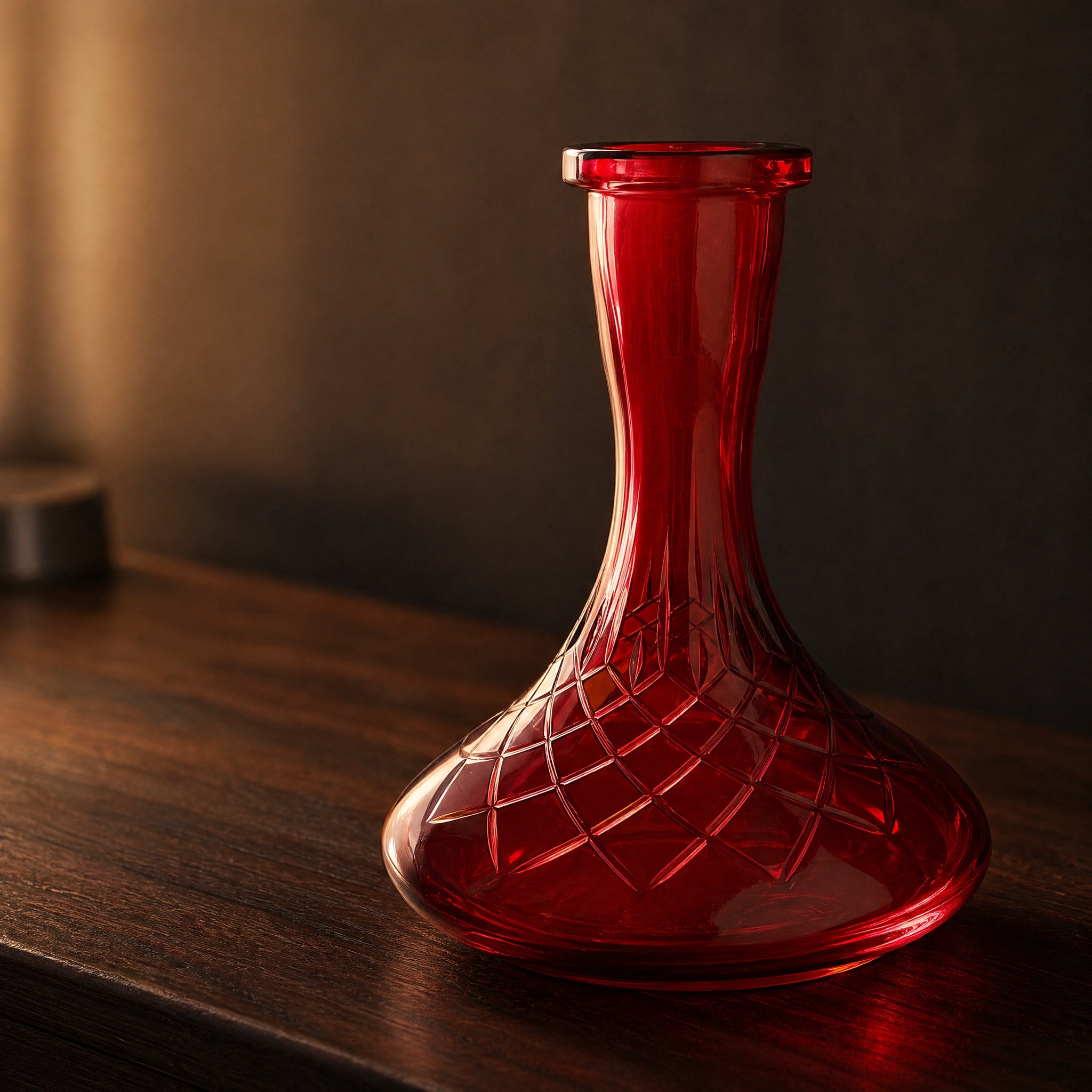 Essentials Ruby Star-Cut shisha vase glowing on a dark walnut sideboard at dusk, ruby tint backlit through cut belly