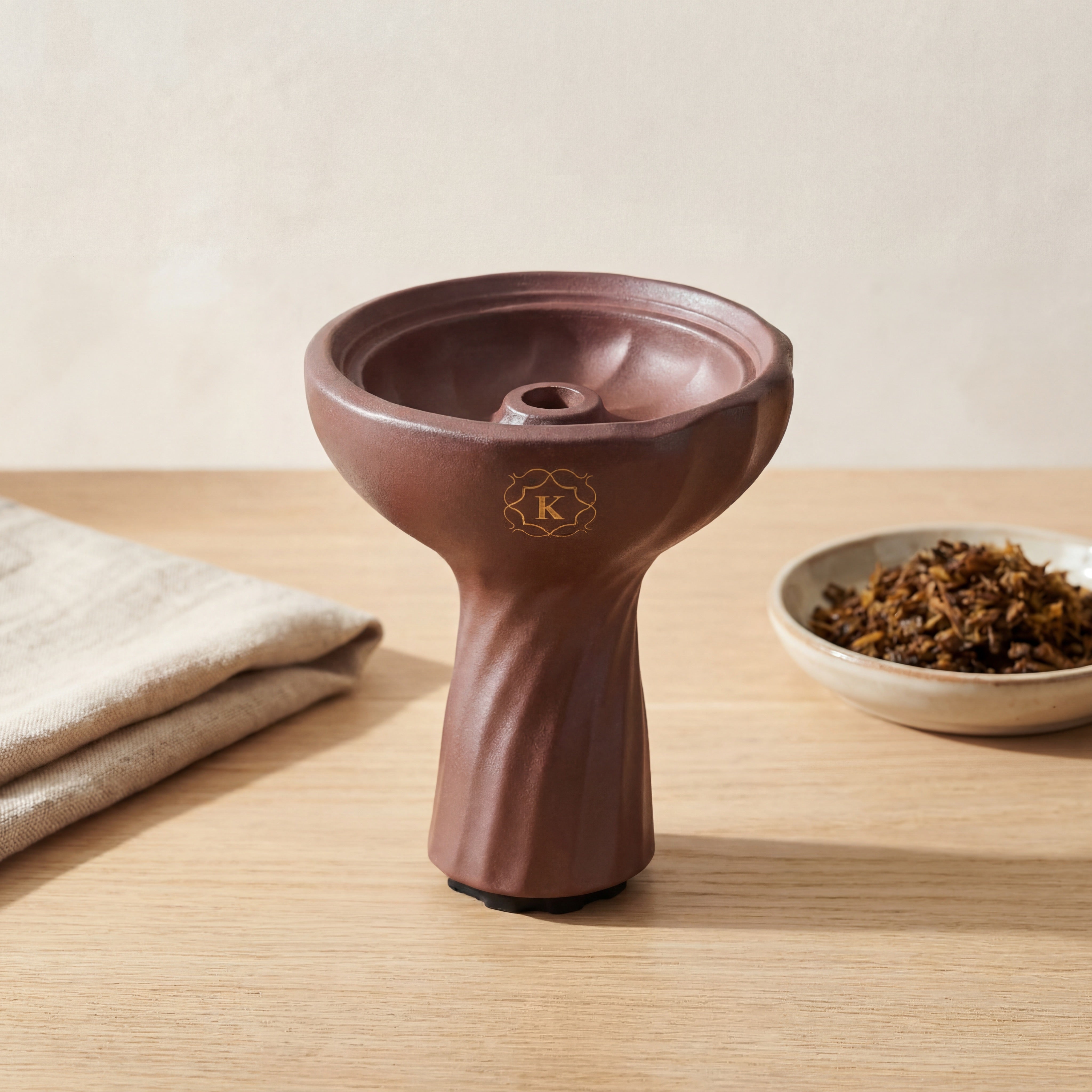 Kaloud Samsaris Kore Qì Tall red clay shisha bowl on pale oak surface with shisha leaf in ceramic dish and linen cloth
