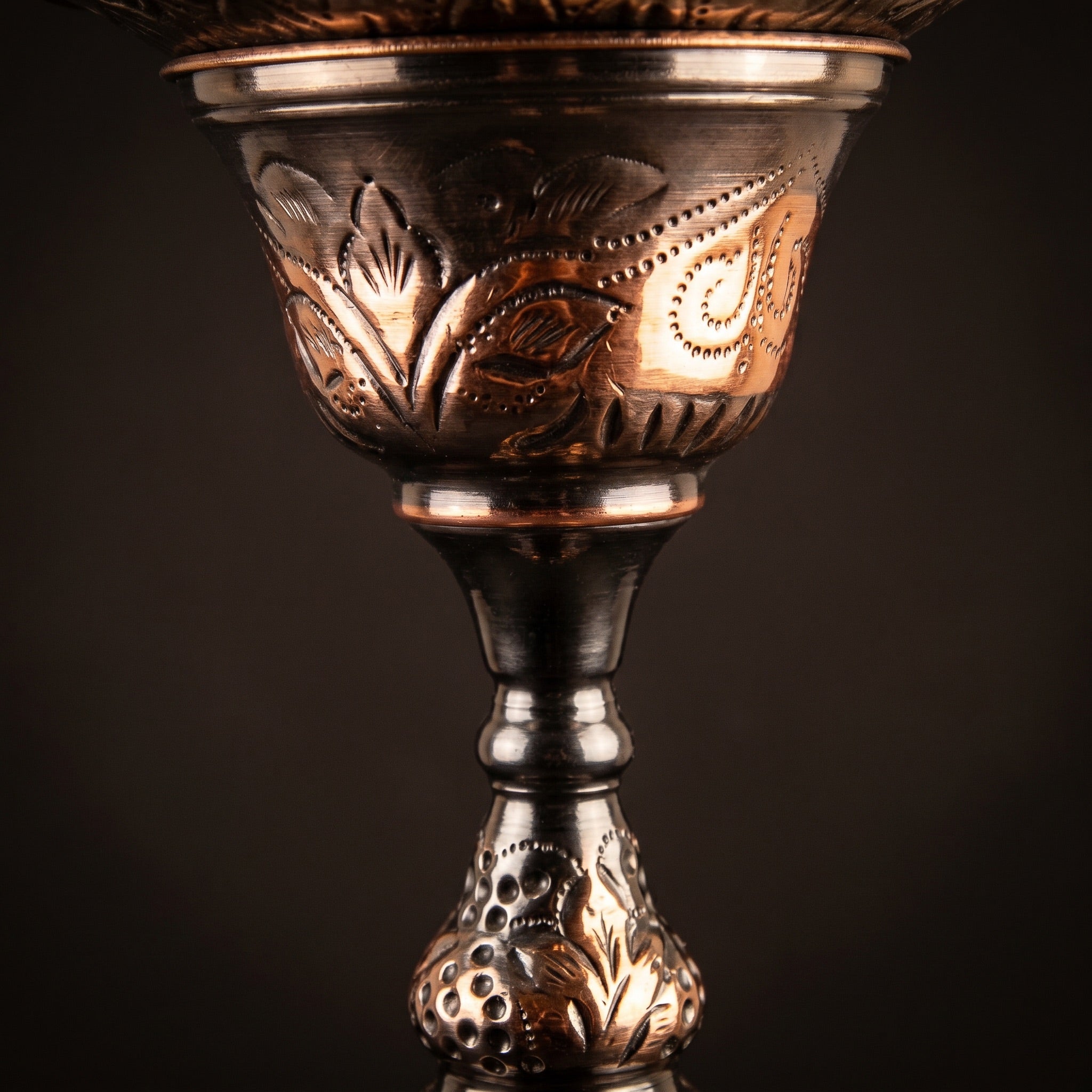 Close-up of the Khalil Mamoon 1566 Oxide Mismatch stem showing hand-struck grape-and-leaf repoussé and oxide tonal variation