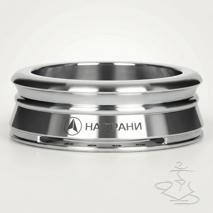 Na Grani On The Edge stainless steel heat management device with mirror-polished ridged bands and dark matte centre band, front three-quarter studio shot on warm white background