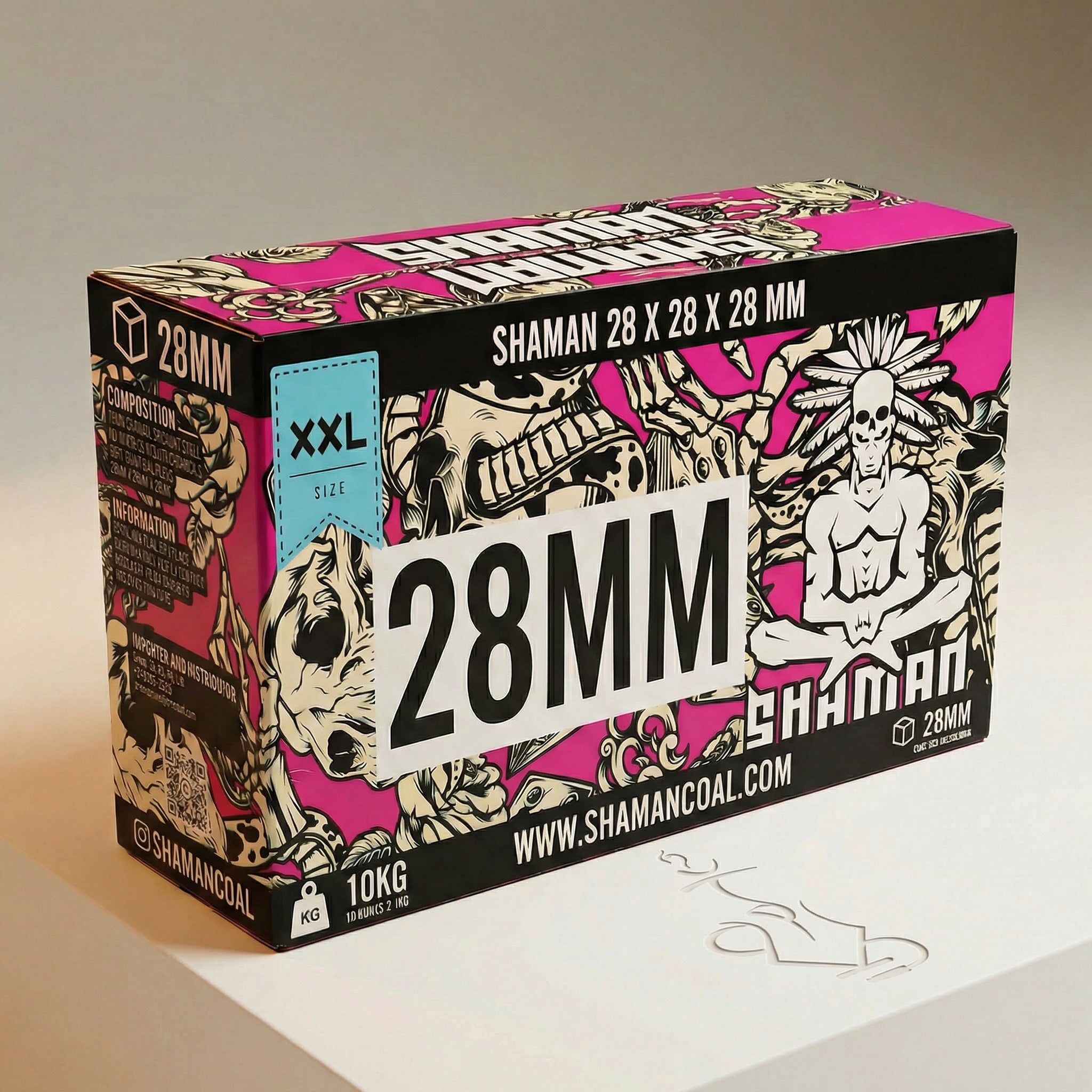 Shaman 28mm coconut shisha charcoal 10kg master case three-quarter view showing wide landscape box with bold 28MM branding and tattoo-style artwork on warm white studio background